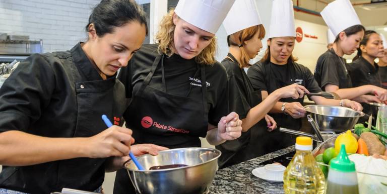Teams participating in a culinary team building event at Palate Team Building Singapore
