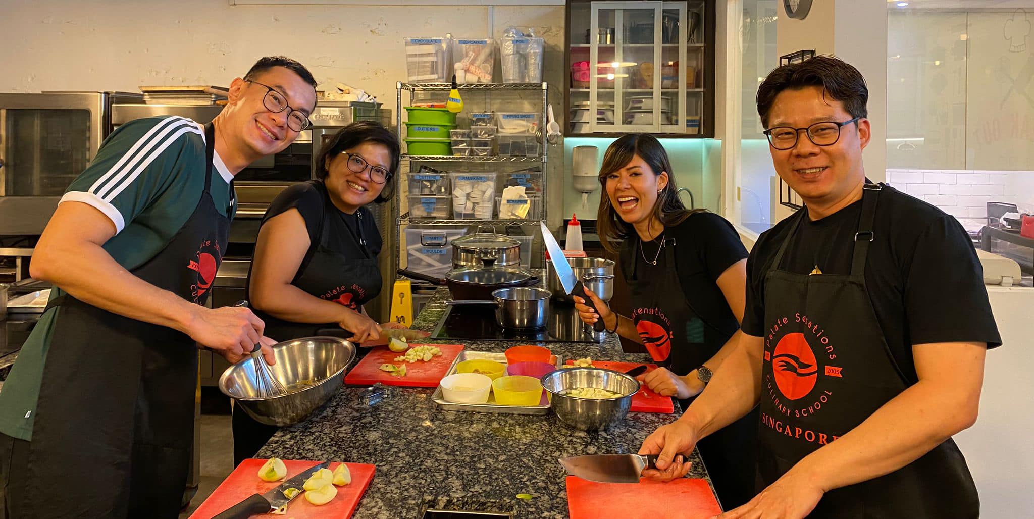 Corporate team collaborating during a cooking ice breaker challenge at Palate Sensations